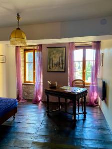 a living room with a table and pink curtains at La maison d'en haut in Josselin