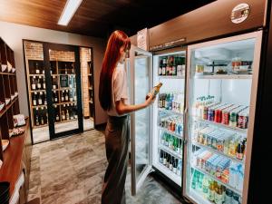 Eine Frau steht vor einem offenen Kühlschrank in der Unterkunft 十二ホテル -福岡空港- in Fukuoka