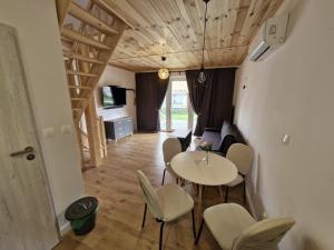 a room with a table and chairs and a living room at Sosnowa Polana Rusinowo in Rusinowo +10 photos