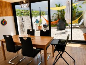 a dining room with a wooden table and black chairs at Casa Elegante V3 Moderna 2 Suítes, Jardim e Garagem Privados in Olhão