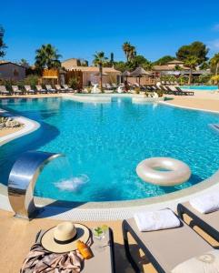 a large swimming pool with a frisbee in the water at FMLODGE mobil home le petit cocon in Valras-Plage