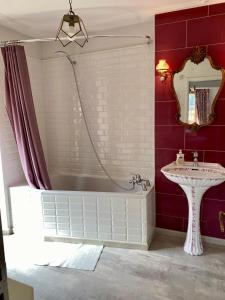 a bathroom with a white tub and a sink at La maison d'en haut in Josselin