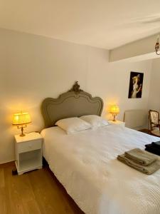 a bedroom with a large white bed with two lamps at La maison d'en haut in Josselin