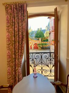 a room with a table and a view of a balcony at La maison d'en haut in Josselin +11 photos