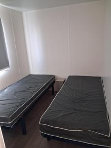 a small room with two beds in it at FMLODGE mobil home le petit cocon in Valras-Plage +8 photos