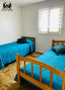 a bedroom with two beds and a bench and a window at Taltal - Casa Nordic in Taltal