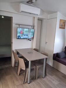 a dining room with a table and chairs at FMLODGE mobil home le petit cocon in Valras-Plage