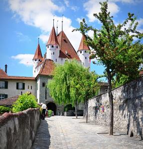 Eine Burg mit einem Mann, der neben einer Steinmauer steht in der Unterkunft The Lab Hotel & Apartments in Thun