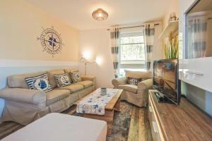 a living room with a couch and a tv at Loddin Ferienwohnung Inselzeit in Loddin