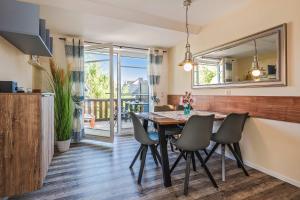 a kitchen and dining room with a table and chairs at Loddin Ferienwohnung Inselzeit in Loddin