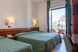 a hotel room with two beds and a balcony at Hotel Montana in Massa Lubrense