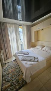a bedroom with a large bed with towels on it at Malta Hotel in Batumi