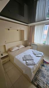 a bedroom with a bed with towels on it at Malta Hotel in Batumi