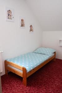 a bed in a room with two pictures on the wall at Ubytování Dědinka in Mladkov