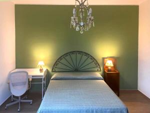 a bedroom with a bed and a desk and a chandelier at Casa Drema - Villa al mare con terrazza in Pescara