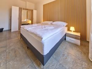 a bedroom with a large bed with white sheets at Teplice Apartments U Schodů in Teplice