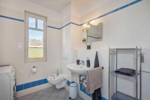 a white bathroom with a sink and a toilet at Ferienwohnung Koralle in Koserow +23 photos