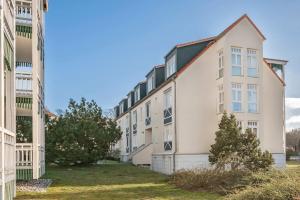a row of buildings with trees in the yard at Ferienwohnung Koralle in Koserow