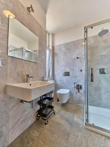 a bathroom with a sink and a shower and a toilet at Teplice Apartments U Schodů in Teplice