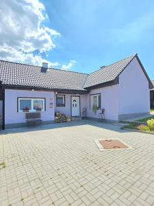 a white house with a patio in front of it at Ubytovanie u Richtára in Klokoč