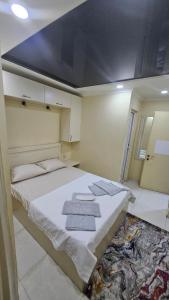 a bedroom with a large bed with towels on it at Malta Hotel in Batumi