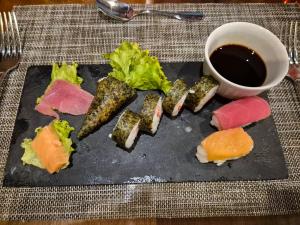a plate of food with sushi and a cup of coffee at Viva paradise in Punta Cana