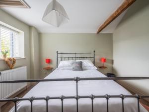 a bedroom with a metal bed with two lamps at Y Cwtsh in Llandeilo
