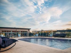 a swimming pool with patio furniture next to a building at Una Argentum 62 in Carbis Bay