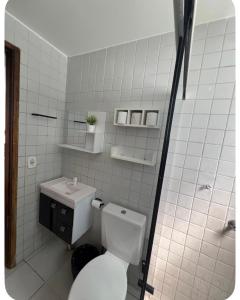 a white bathroom with a toilet and a sink at Apto no Janga in Paulista