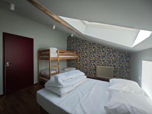 a bedroom with a bed with white sheets at Domaine du Moulin Français in Champougny