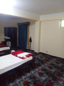 a hotel room with two beds and a carpet at UK Residencia in Murree
