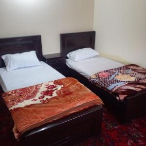 two beds sitting next to each other in a room at UK Residencia in Murree