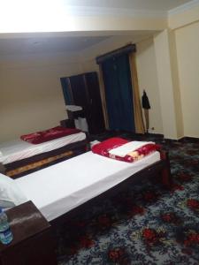a bedroom with two beds in a room at UK Residencia in Murree +5 photos
