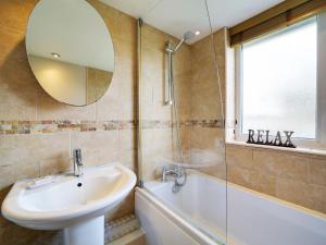 a bathroom with a sink and a tub and a mirror at Sea Thrift in Port Isaac