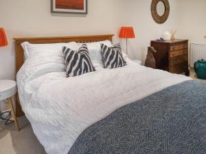 a bed with two pillows on it in a bedroom at Alscott Cottage in Bishops Tawton