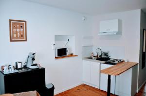 a kitchen with white cabinets and a counter top at Dormir près de Brioude - studio 'esprit vacances' in Fontannes +29 photos