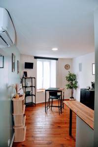 a living room with a table and a dining room at Dormir près de Brioude - studio 'esprit vacances' in Fontannes