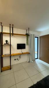 a living room with a flat screen tv on a wall at Apartamento Studio 003 in Caruaru