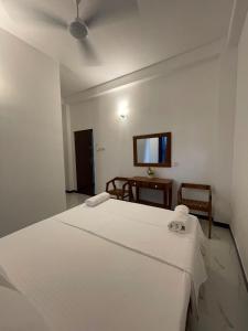 a bedroom with a white bed and a table at Rest Inn Tourist Hotel in Gampaha +5 photos