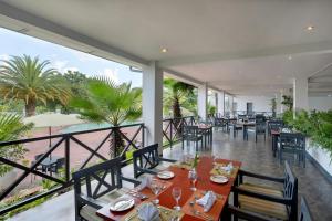 a restaurant with tables and chairs on a balcony at Protea Hotel by Marriott Chingola in Chingola