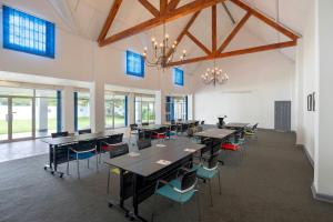 a large room with tables and chairs and windows at Protea Hotel by Marriott Chingola in Chingola +115 photos