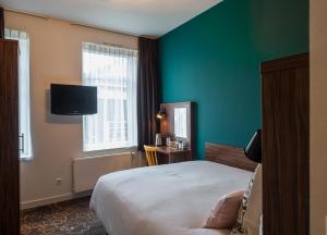 a hotel room with a bed and a green wall at Linden Hotel in Amsterdam