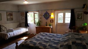 a bedroom with a bed and two windows at Domaine de Las Planques in Vaudreuille