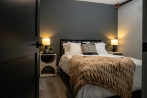ein Schlafzimmer mit einem Bett und zwei Nachttischen mit Lampen in der Unterkunft Three Trails Downtown Elkin in Elkin