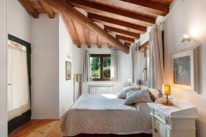 a bedroom with a bed in a room with wooden ceilings at Villa Il Rossignolo con Piscina in Grassina +57 photos