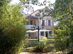 a white house with a street light in front of it at Domaine de Las Planques in Vaudreuille