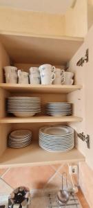 a kitchen with plates and cups and dishes on shelves at Reihenhaus Römmer in Altenstadt +28 photos