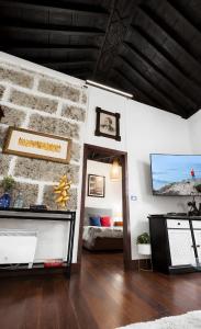 a living room with a stone wall and a couch at Casa Tradicional Canaria - Chico in Garachico +17 photos