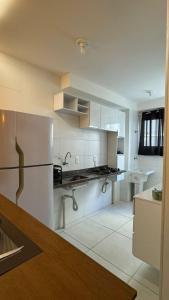 a white kitchen with a refrigerator and a sink at Apartamento Studio 003 in Caruaru +8 photos