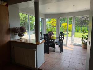 a dining room with a table and chairs and windows at Dorupes House in Liepāja